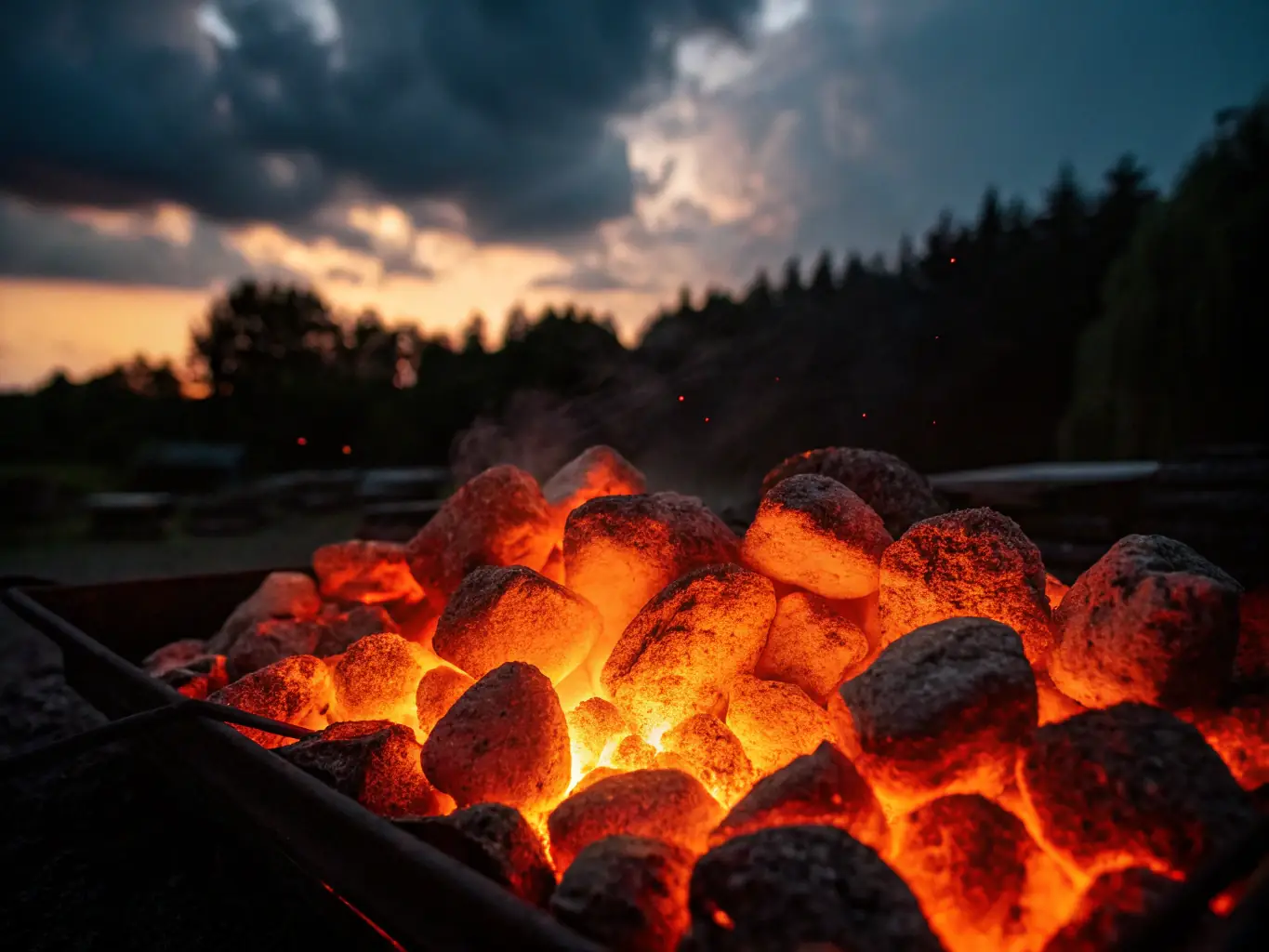 A close-up shot of Premium Grilling Charcoal briquettes, highlighting their uniform shape and texture, placed next to a glowing grill with steaks cooking on it.